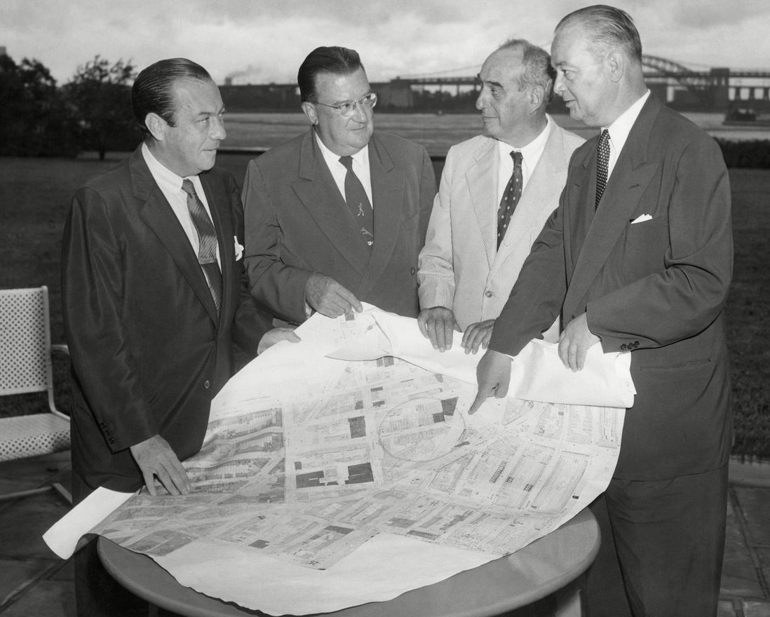 Walter O'Malley, president of the Brooklyn Dodgers, meets with city officials to discuss ideas for a modern stadium in Brooklyn, looking over a map on a porch of Mayor Robert F. Wagner's Gracie Mansion residence. 1955.